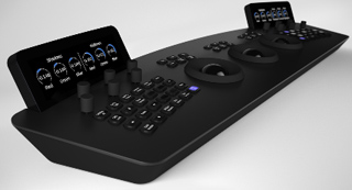 A black professional audio mixing console with various knobs, buttons, and two small digital displays.
