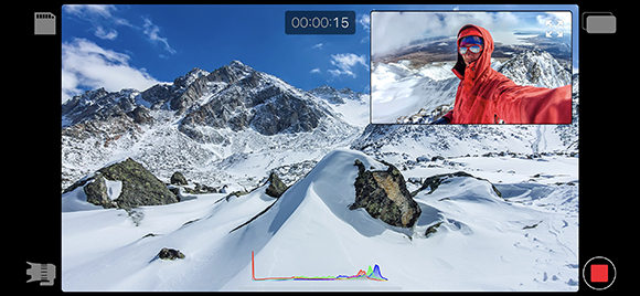 A digital interface shows a snowy mountain range and a small inset of a person in a red jacket filming themselves.