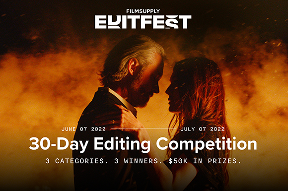 A man and woman face each other closely against a warm, glowing, smoky orange background.