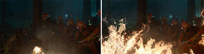 Firefighters in protective gear using tools to fight a large blaze in a dark forest.