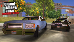 A light blue vintage car drives down a street ahead of a black and white police car.