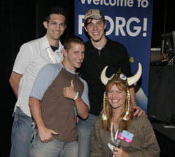 Four smiling people posing in front of a blue banner that says "Welcome to PDRG!"