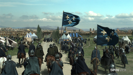 Soldiers on horseback ride toward a castle courtyard under blue flags with gold fleur-de-lis.