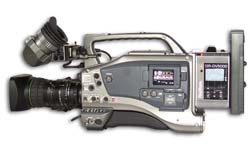 A silver professional handheld video camera with a large lens and an attached viewfinder.