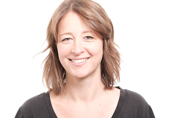 A smiling woman with shoulder-length brown hair looking at the camera against a white background.
