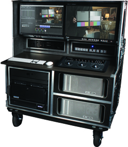 A mobile video editing suite with dual monitors, control surfaces, and rack-mounted hardware.