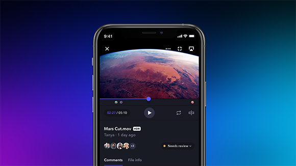 A smartphone screen showing a video of a reddish planetary landscape with clouds.