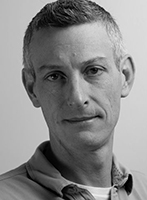 Black and white headshot of a man looking directly at the camera.