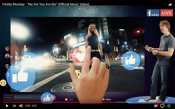 A music video frame showing a woman on a city street, overlaid with large blue thumbs-up and pink heart icons.