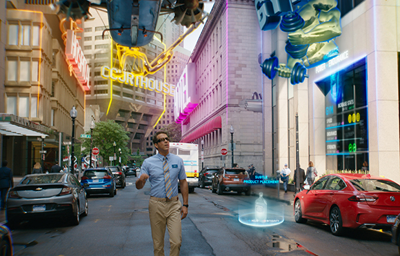 A man in a blue shirt walks down a city street lined with glowing holographic advertisements.