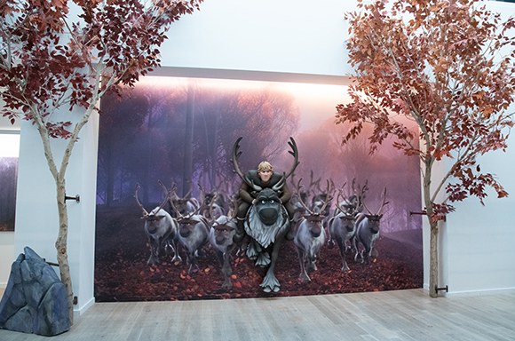 A display featuring a character riding a reindeer, with a herd of reindeer behind him, set against a forest backdrop. Decorat