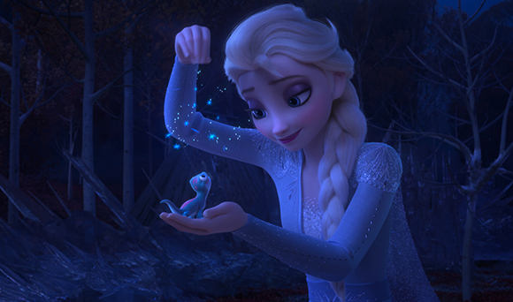 A blonde woman in a light blue gown looks down at a tiny blue creature in her palm amidst a dark forest.