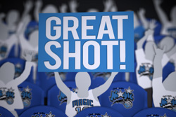 A blue rectangular sign with white text reading 'GREAT SHOT!' surrounded by cutout basketball player figures.