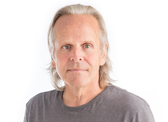 A middle-aged man with light brown hair and green eyes looking directly at the camera against a white background.