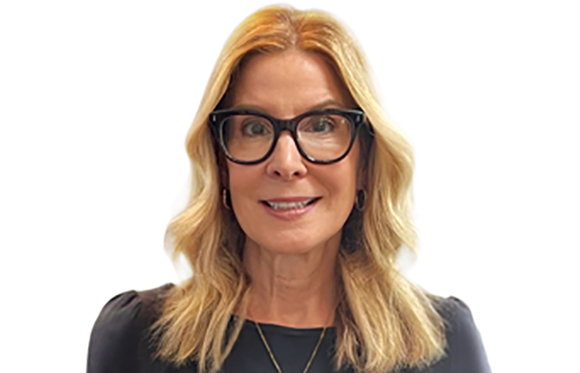 A blonde woman with black-rimmed glasses smiling against a white background.