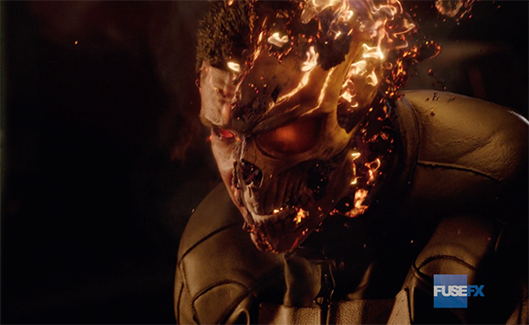 A figure with a skull-like face and glowing red eyes, partially covered in flames and embers.