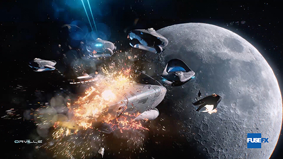 Several spaceships fly near a large cratered moon as one ship explodes in a burst of fire and debris.