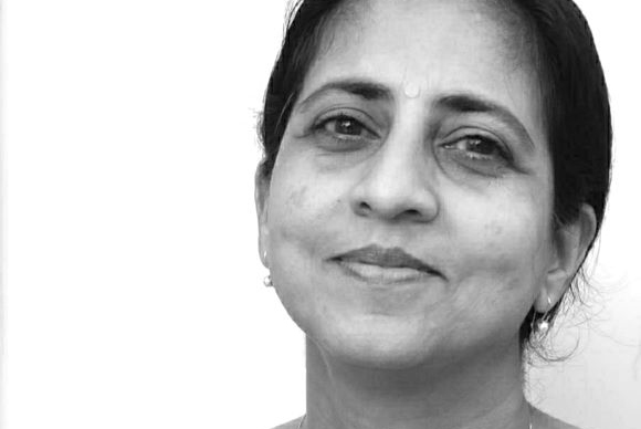 Black and white close-up portrait of a woman looking at the camera with a slight smile.