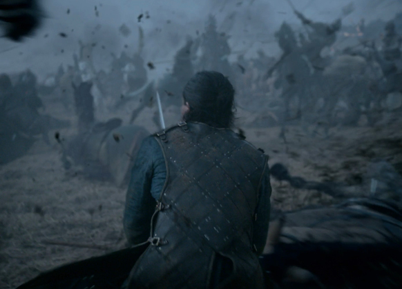 A person in dark armor seen from behind, looking toward a foggy, crowded battlefield with silhouettes of riders.