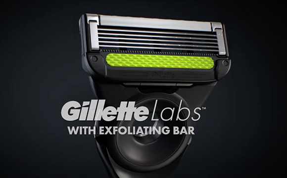 A close-up of a Gillette Labs razor featuring a lime green exfoliating bar.