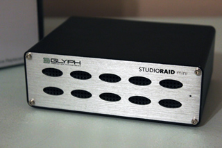 A black and silver Glyph StudioRAID mini rectangular electronic device with ventilation holes.