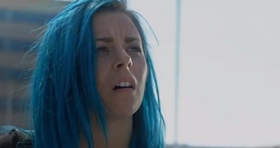 A woman with long, vibrant blue hair looks upward with a worried or confused facial expression.