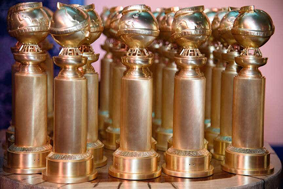 Multiple gold trophies with globe-shaped tops arranged in rows on a circular surface.
