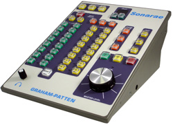 An angled view of a Sonarae Graham-Patten audio control panel with numerous colored buttons and a large silver knob.