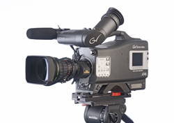 A professional black video camera with a large lens and microphone mounted on a tripod against a white background.