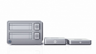 Three silver rectangular electronic devices of different sizes arranged on a white reflective surface.
