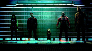 Five silhouetted characters stand in a row against a bright green horizontal slatted background.