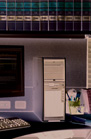 A vertical computer tower stands on a desk next to a monitor and a keyboard.