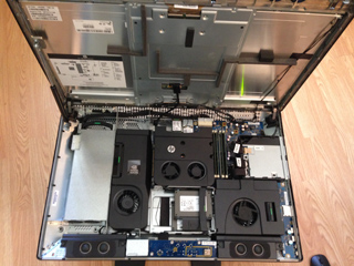 An open computer case revealing internal components like fans, circuit boards, and drives.