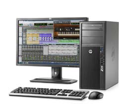 A desktop computer setup featuring a monitor displaying music production software, a tower, keyboard, and mouse.