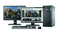 Two computer monitors displaying motorcycle imagery, a black tower PC, a keyboard, and a mouse.