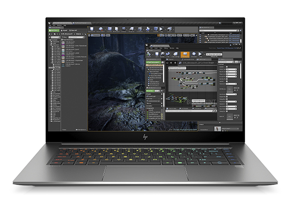 Silver HP laptop open on a desk showing a complex video editing software interface with a forest scene.