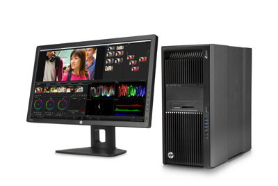 A black HP desktop tower next to a wide computer monitor displaying video editing software.