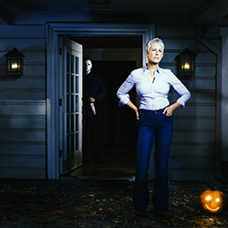 A woman stands on a porch with a jack-o'-lantern while a masked figure with a knife lurks in the doorway behind her.