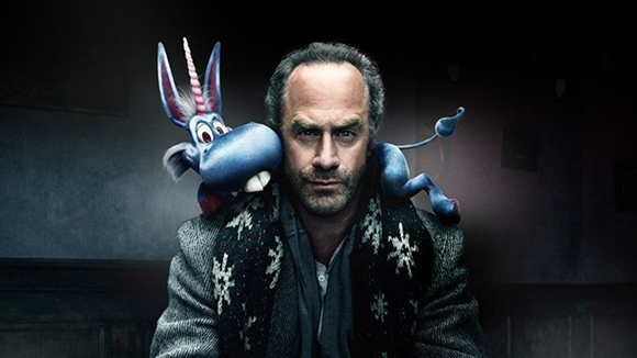 A man looking forward with a blue cartoon donkey perched on his shoulders.