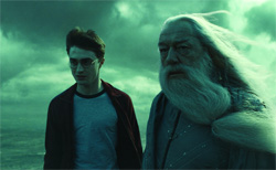 A young man in glasses and an elderly man with a long white beard stand under a green, cloudy sky.