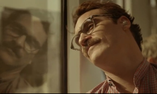 A man with glasses and a mustache leans his head against a window, looking upward.