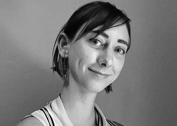 Black and white close-up portrait of a woman with short dark hair smiling slightly.