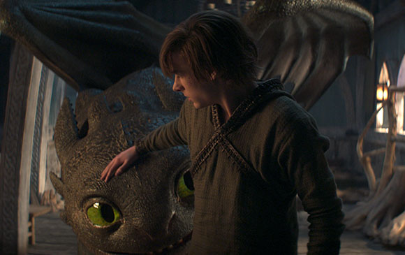 A young man with brown hair reaches out to pet the head of a dark, scaled dragon with large green eyes.