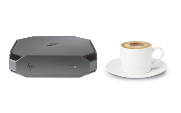 A small grey HP Z workstation sits next to a white cup of cappuccino on a saucer.