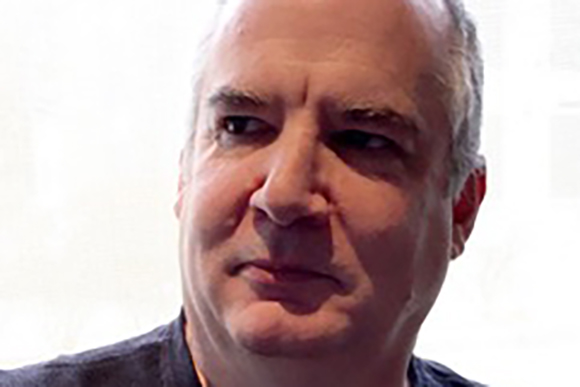 Close-up of a middle-aged man with short graying hair looking off-camera.