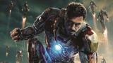 A man in dark metallic armor lunges forward with a glowing blue light on his chest.