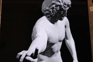 A 3D wireframe mesh overlaying a classical male marble sculpture against a black background.
