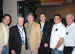 Six men standing side-by-side in a group photo indoors.
