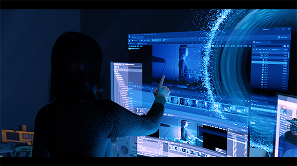 A person reaches toward a glowing, blue holographic display featuring code, video windows, and a swirling ring.