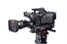 A professional black video camera mounted on a tripod against a white background.
